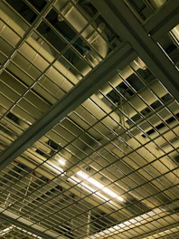 Wide shot of a commercial office ceiling showing neatly arranged wiring and industrial lighting.