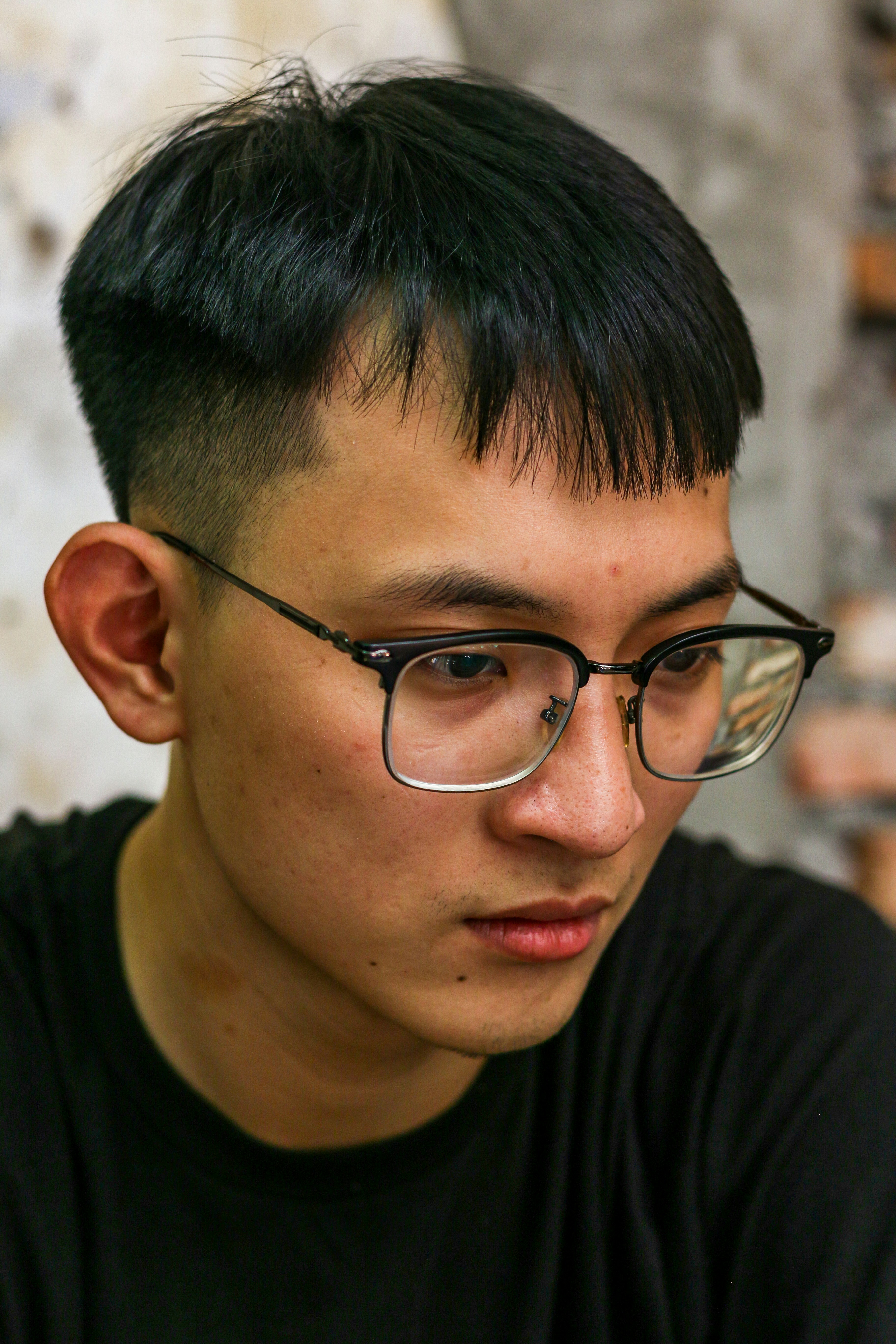 a young man with a black shirt and glasses