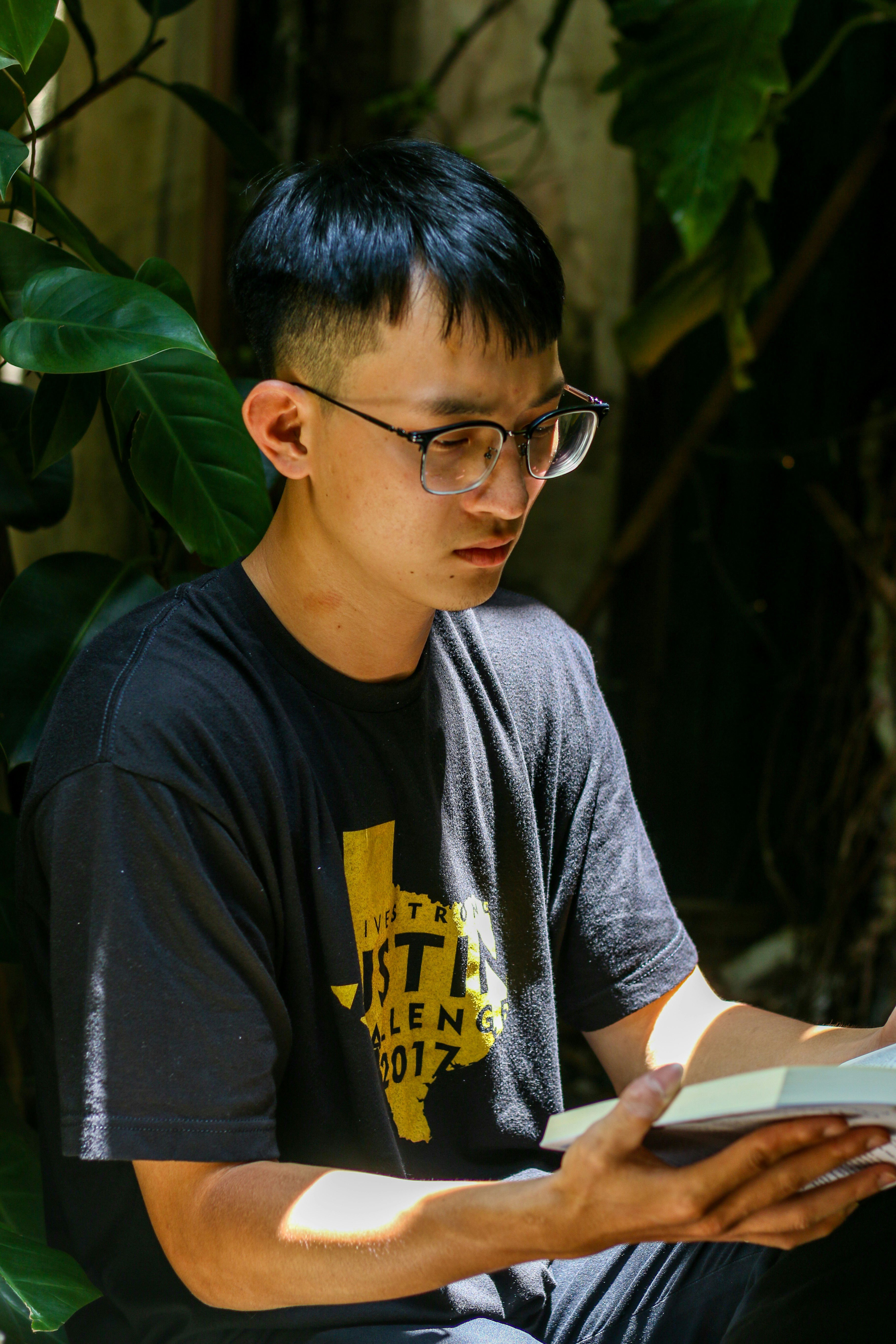 a young man sitting down reading a book