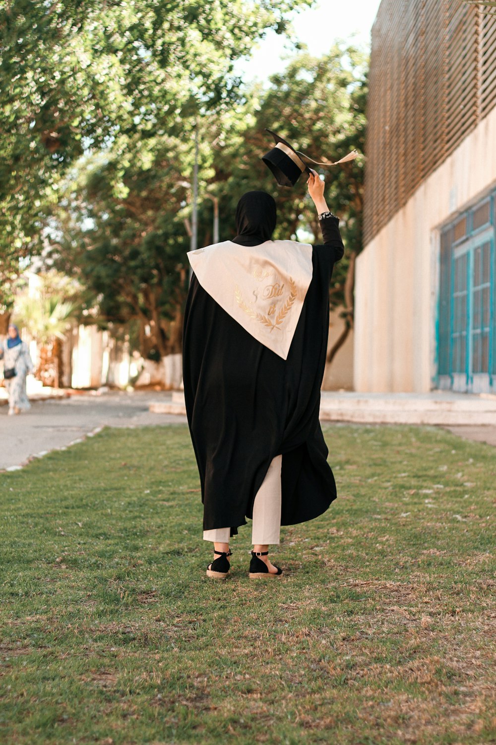 a person in a graduation gown throwing a hat in the air