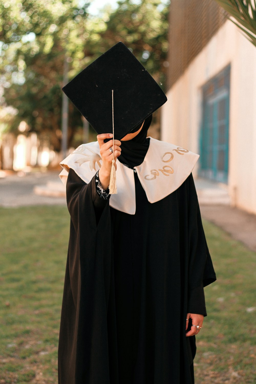 una persona in un abito di laurea che tiene un bastone