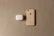 Flat lay of blush pink luméa AirPods cover on a cream background with subtle pastel accents.