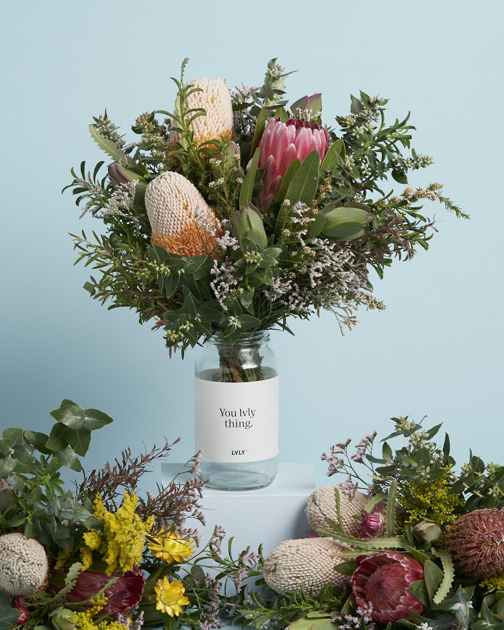 a vase filled with lots of flowers on top of a table