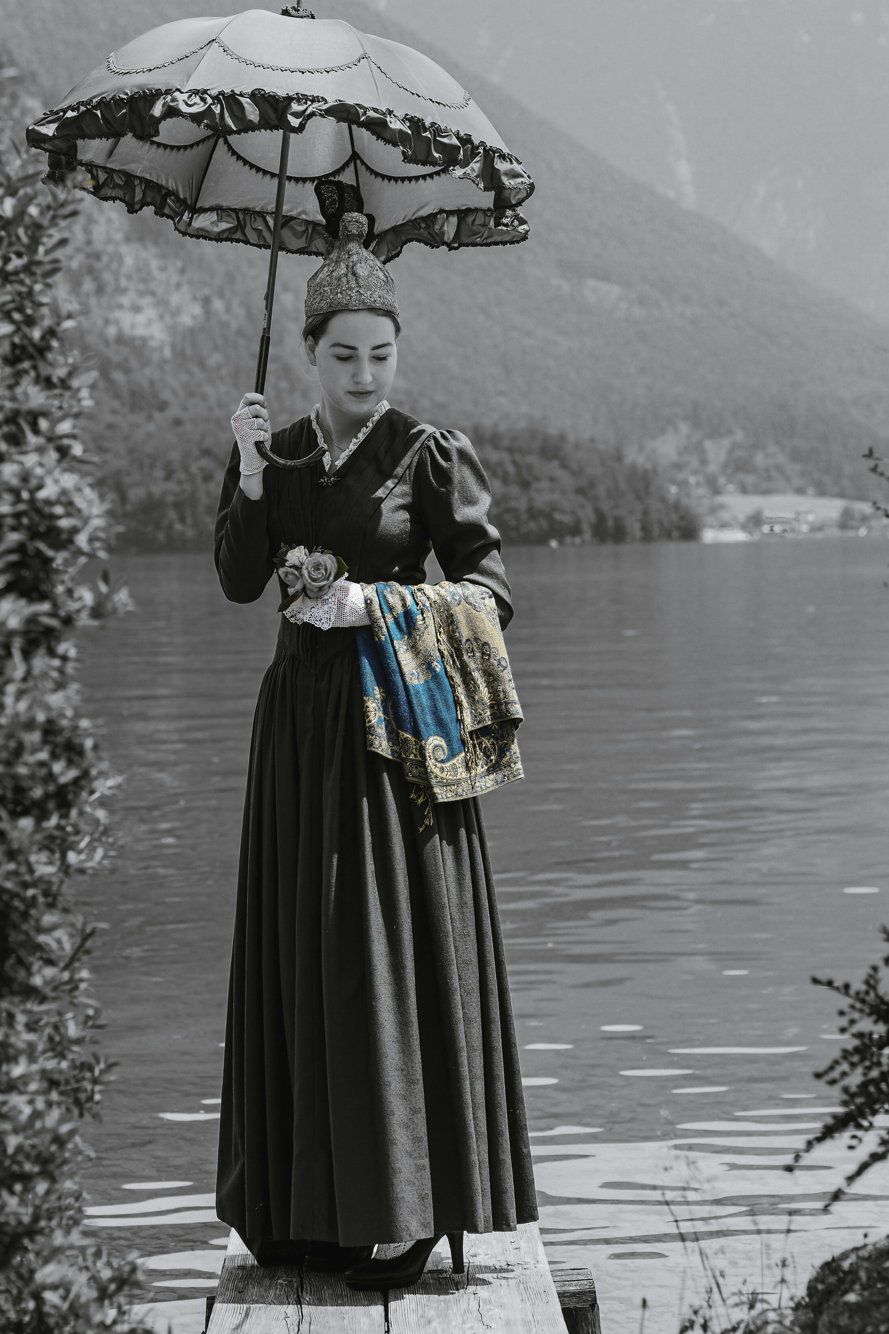 a woman standing on a dock holding an umbrella