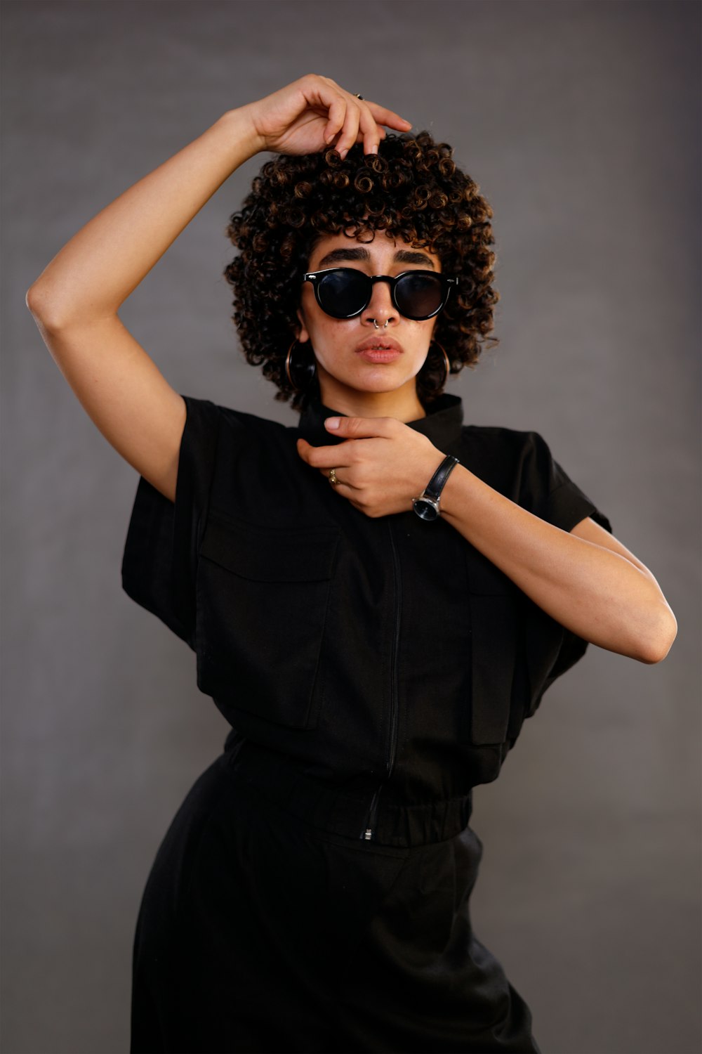 a woman wearing sunglasses and a black dress