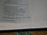 An open book displaying text from a religious scripture with passages discussing prophets and their actions. The text is printed on a page with a slightly yellowed and aged appearance.