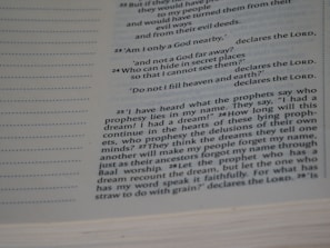 A close-up view of a book page featuring a passage in English. The text includes biblical references, with some parts in bold and the word 'LORD' prominently displayed multiple times. The layout includes line numbers on the left and the text is formatted in a serif font.