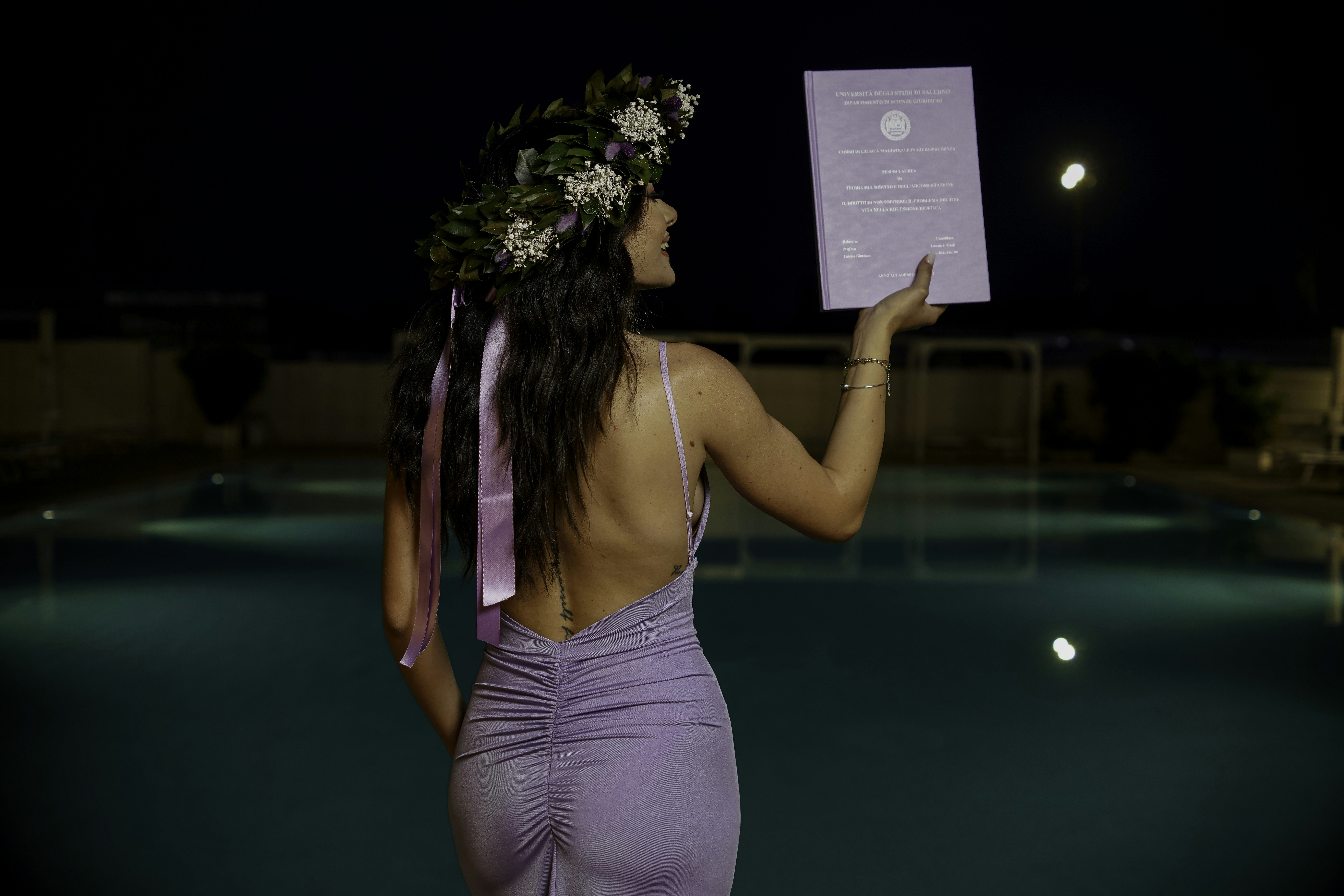 a woman in a purple dress holding up a piece of paper