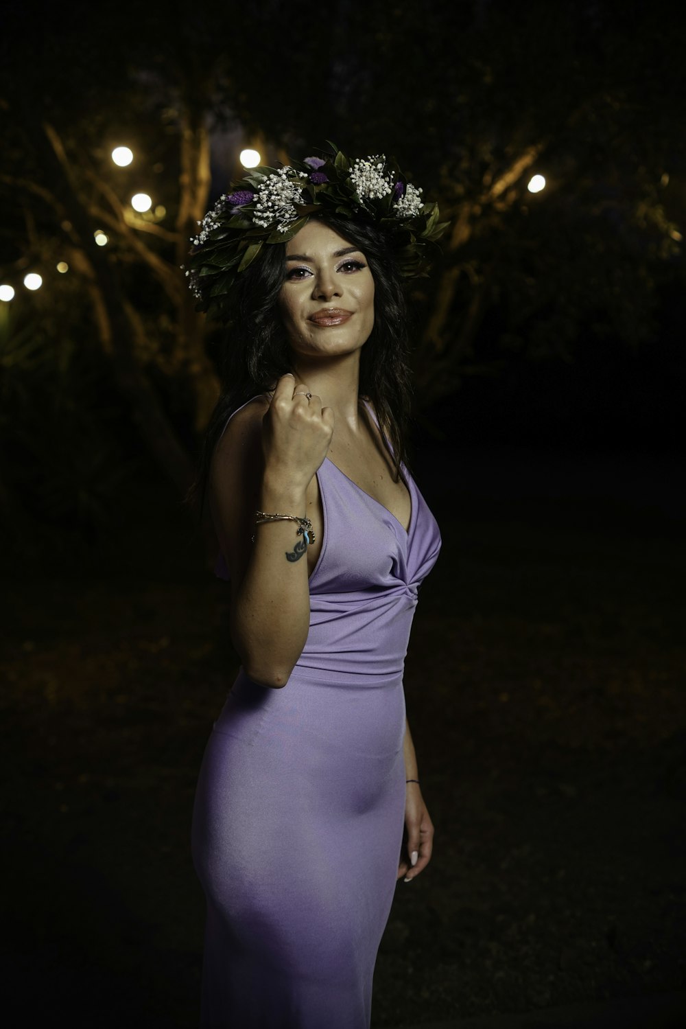 頭に花の冠が付いた紫色のドレスを着た女性