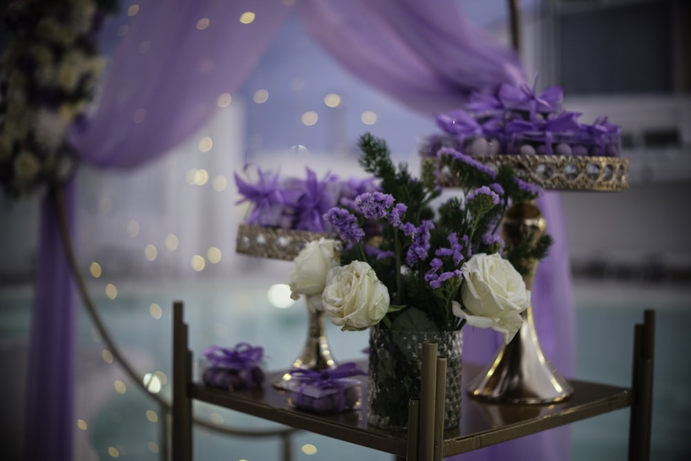 Flores púrpuras y blancas en jarrones sobre una mesa