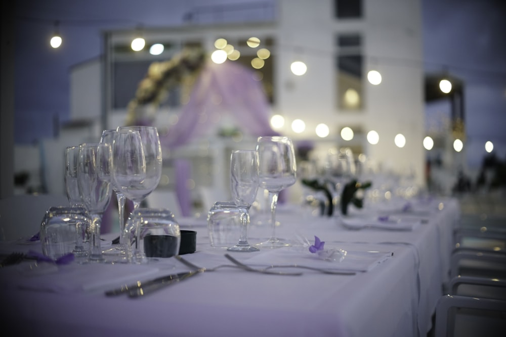 a table set up with wine glasses and silverware