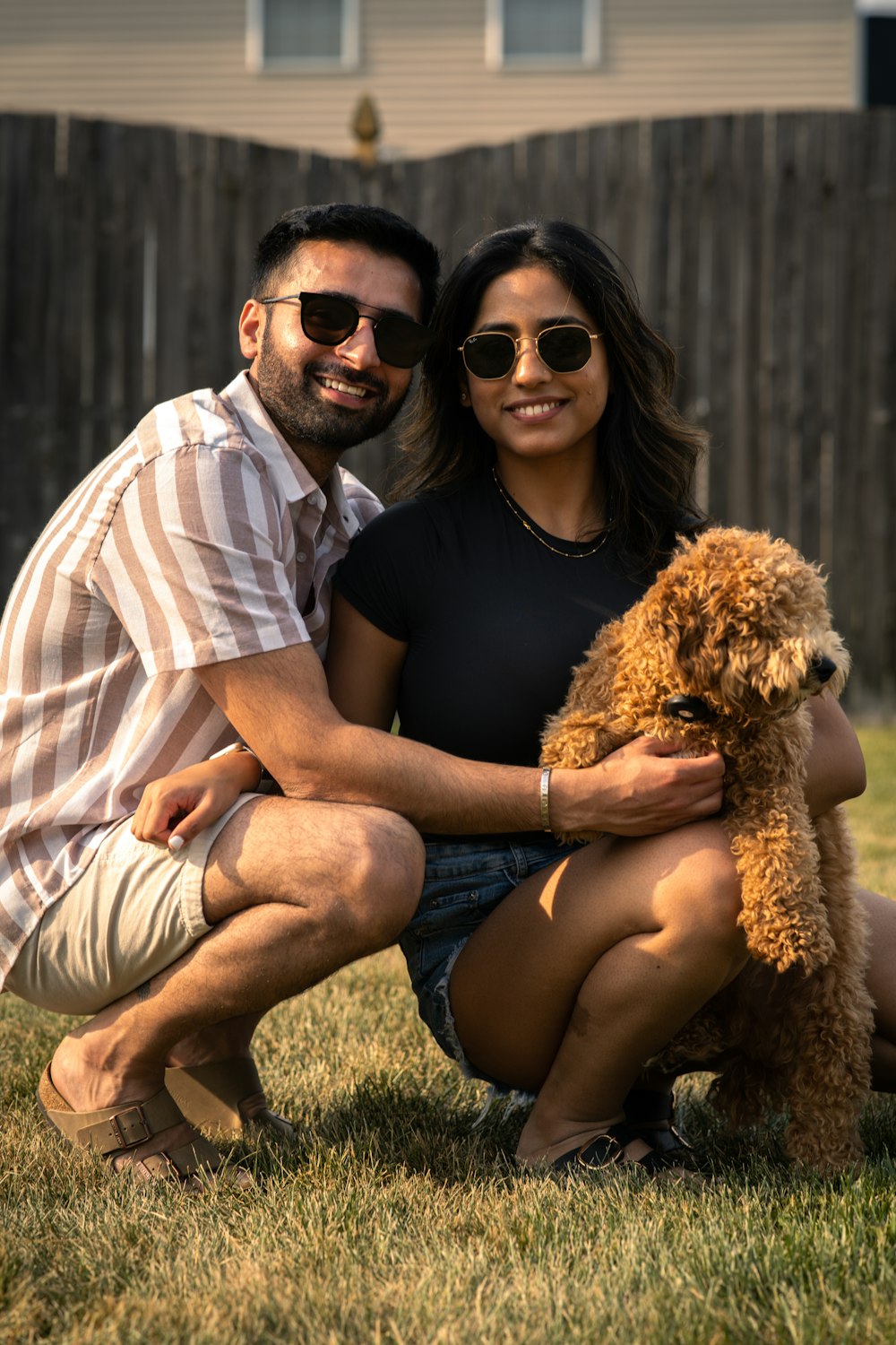 a man and a woman pose for a picture with a dog
