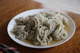 Close-up of freshly made bakmi Jawa noodles on a wooden table.