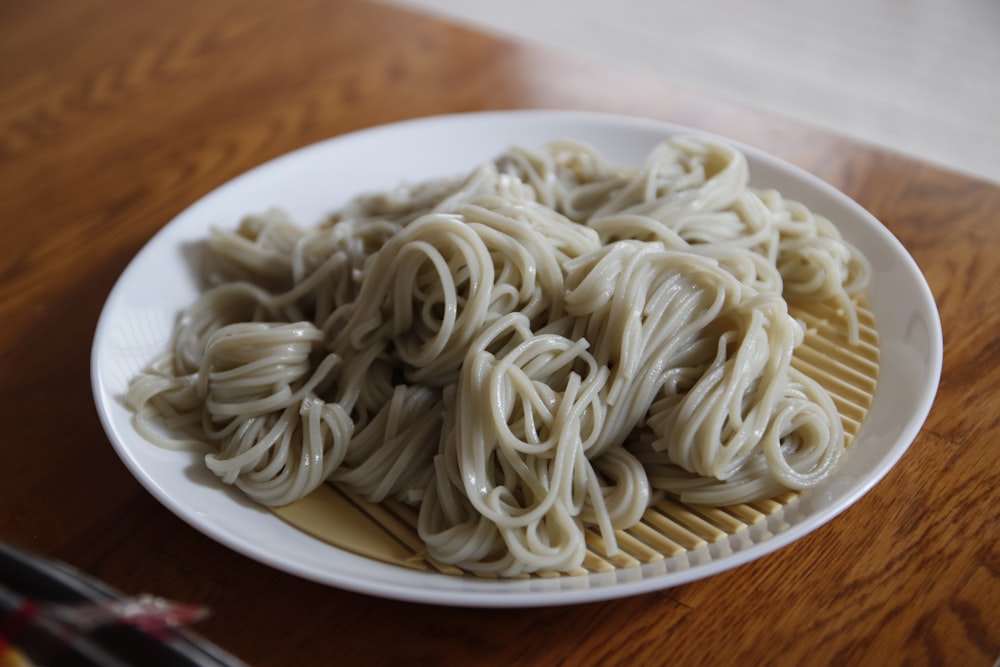 a plate of noodles on a wooden table