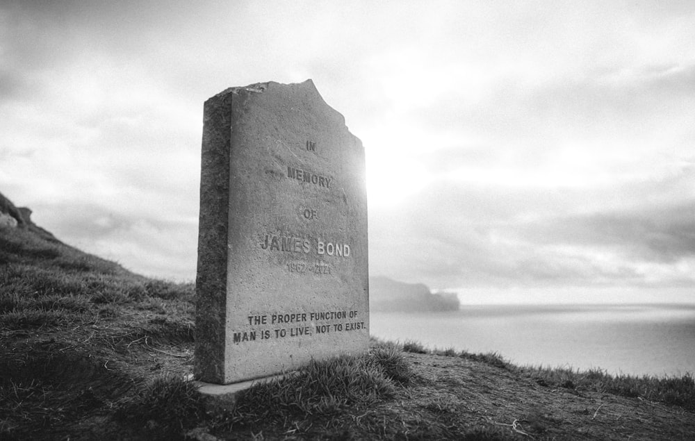 um monumento de pedra sentado no topo de uma colina coberta de grama