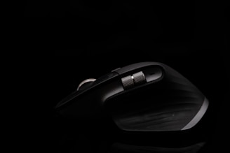 A sleek ergonomic mouse resting on a soft wrist support pad.