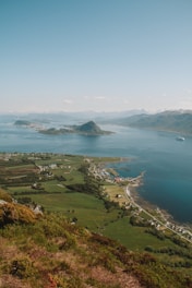 A scenic view of a coastal landscape with a ship in the distance.