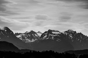 A serene mountain range under a dramatic cloudy sky
