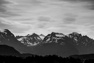 A serene mountain range under a dramatic cloudy sky