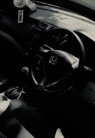 A sleek car interior with a stylish car perfume diffuser releasing a gentle mist.