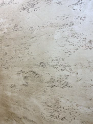 Wall detail showing sandy texture with soft ochre highlights.