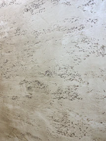 Wall detail showing sandy texture with soft ochre highlights.