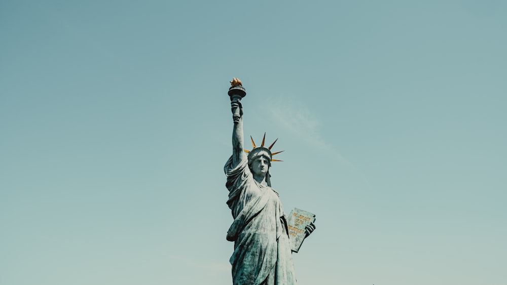 a statue of liberty holding a flag in the air