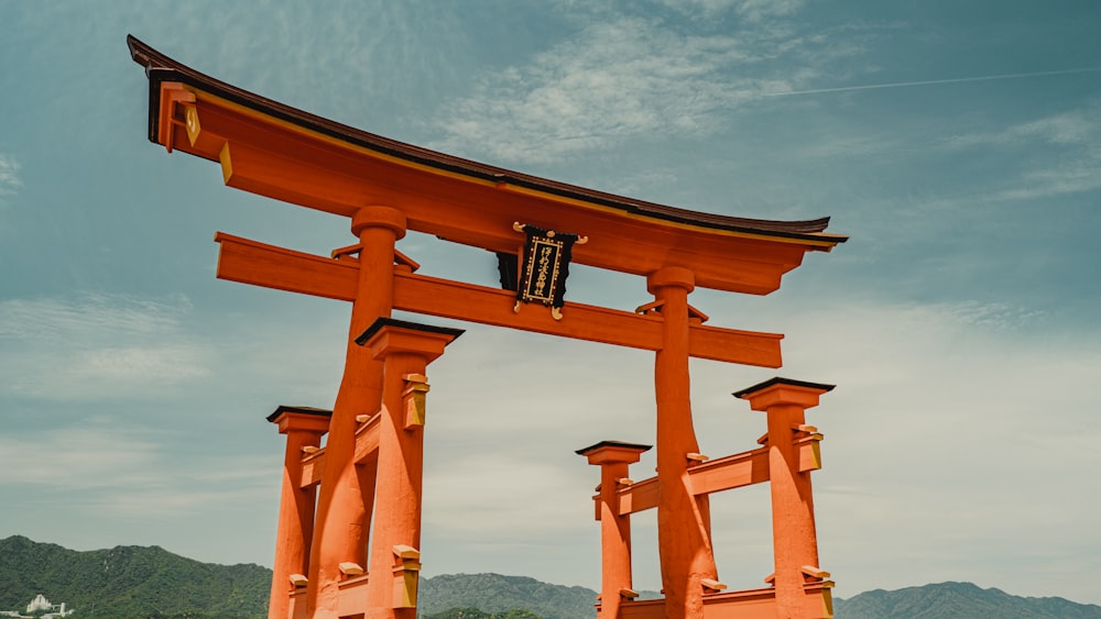 a large orange gate with a sky background