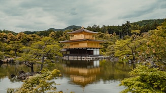 a pagoda in the middle of a lake surrounded by trees