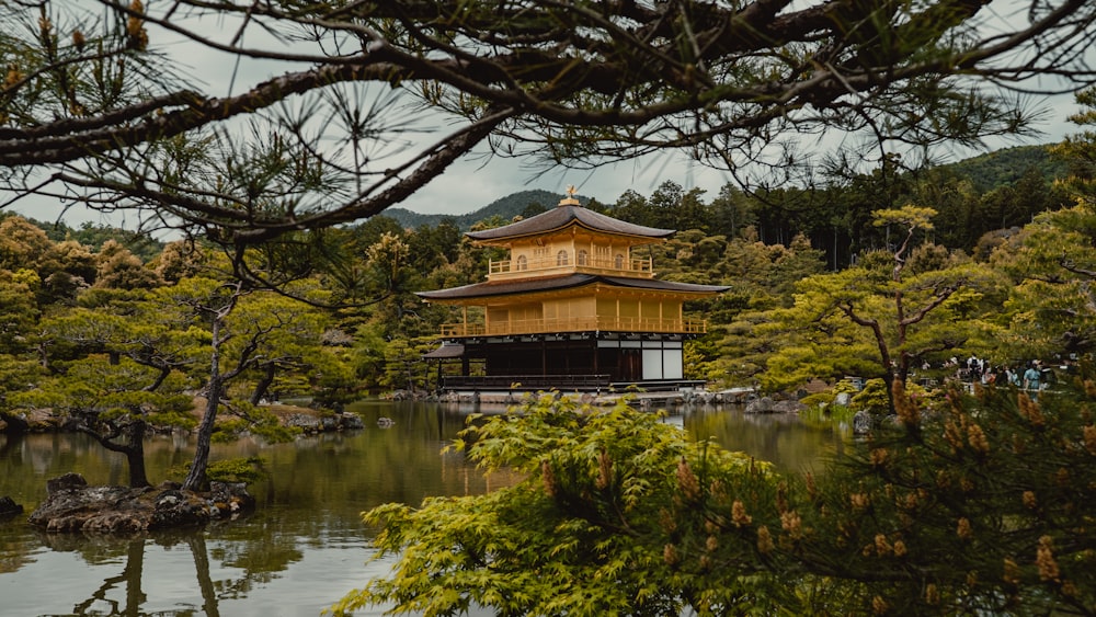 a pagoda in the middle of a pond surrounded by trees