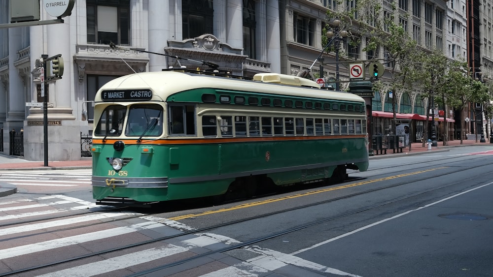 a green trolley car on a city street