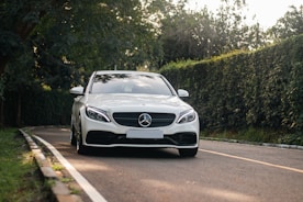 a white car is driving down the road