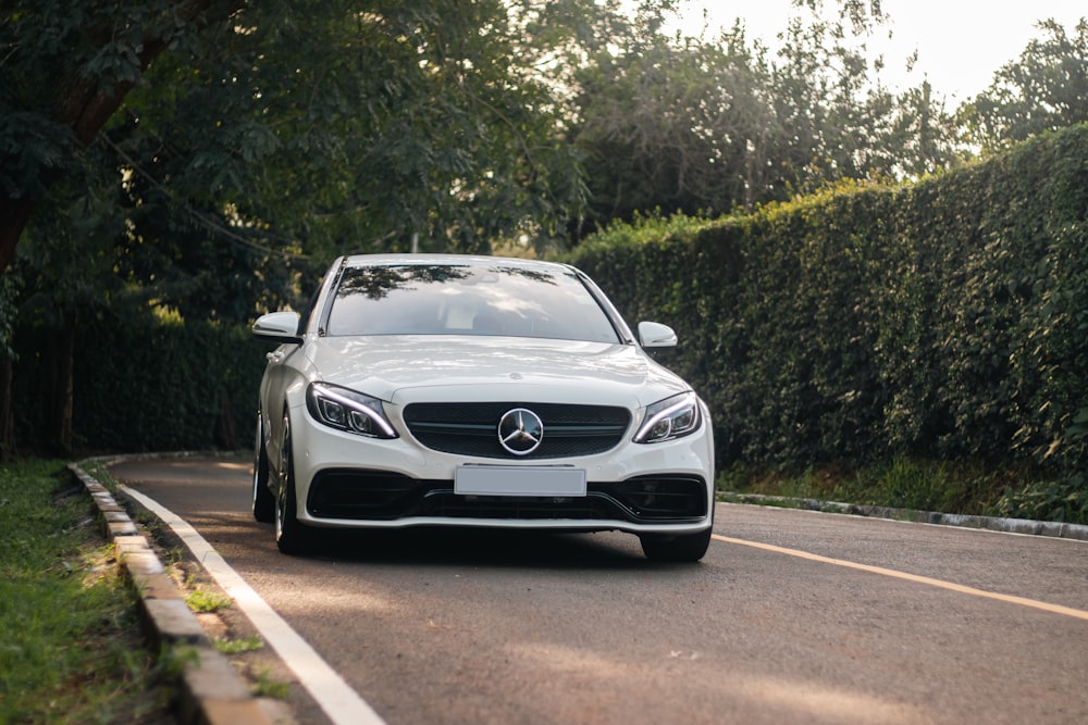 a white car is driving down the road