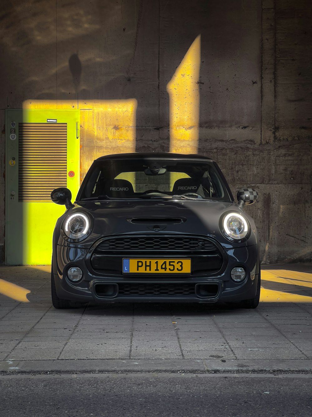 a black car parked in front of a yellow door