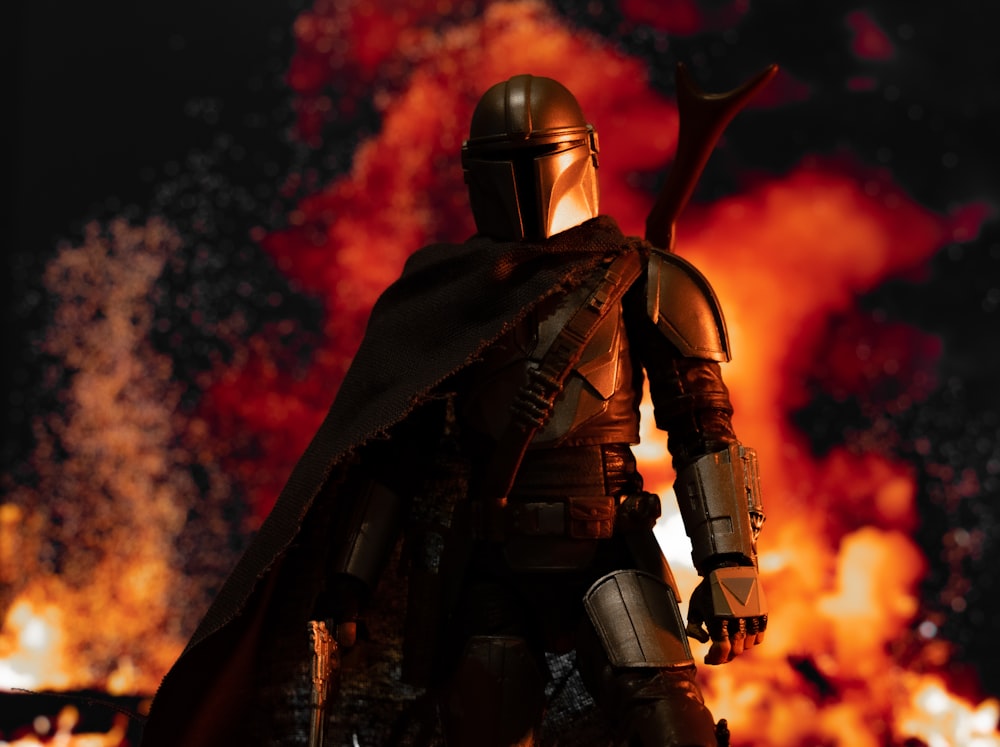 a star wars action figure standing in front of a fire