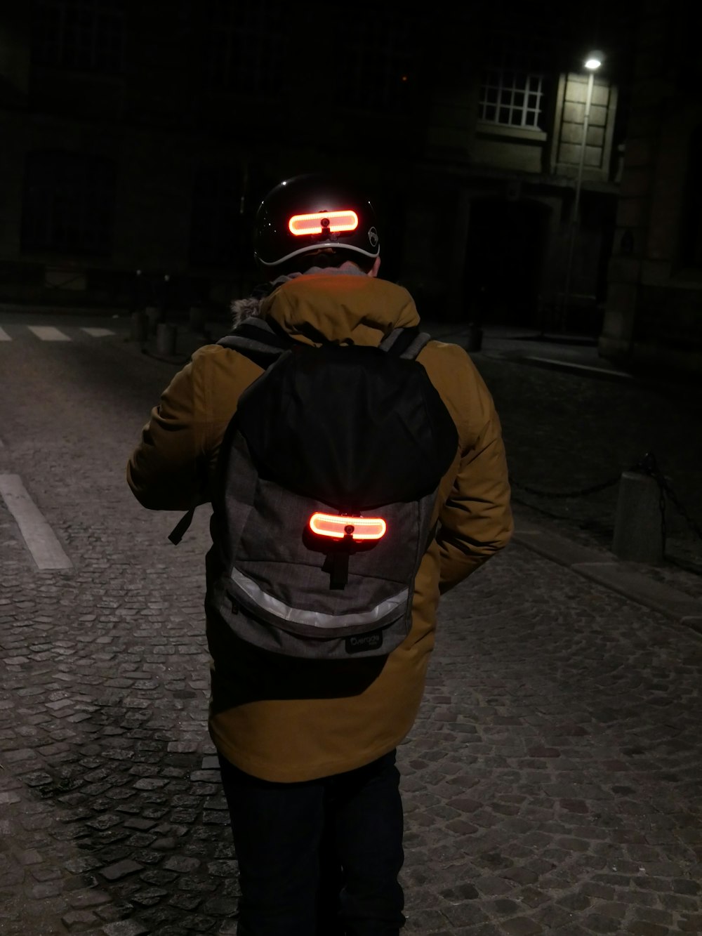 a person with a back light on walking down a street
