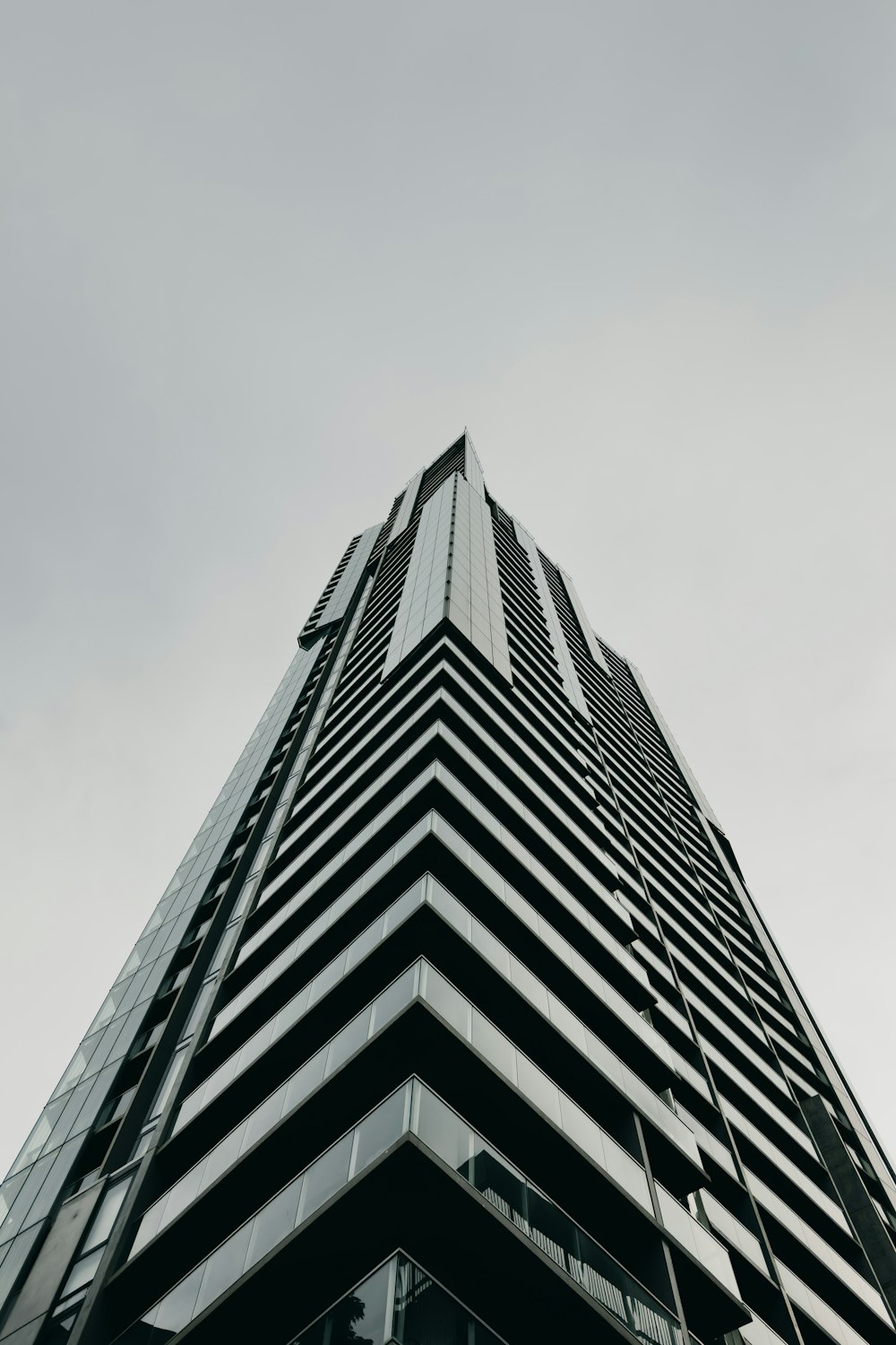 a tall black and white building with a sky background