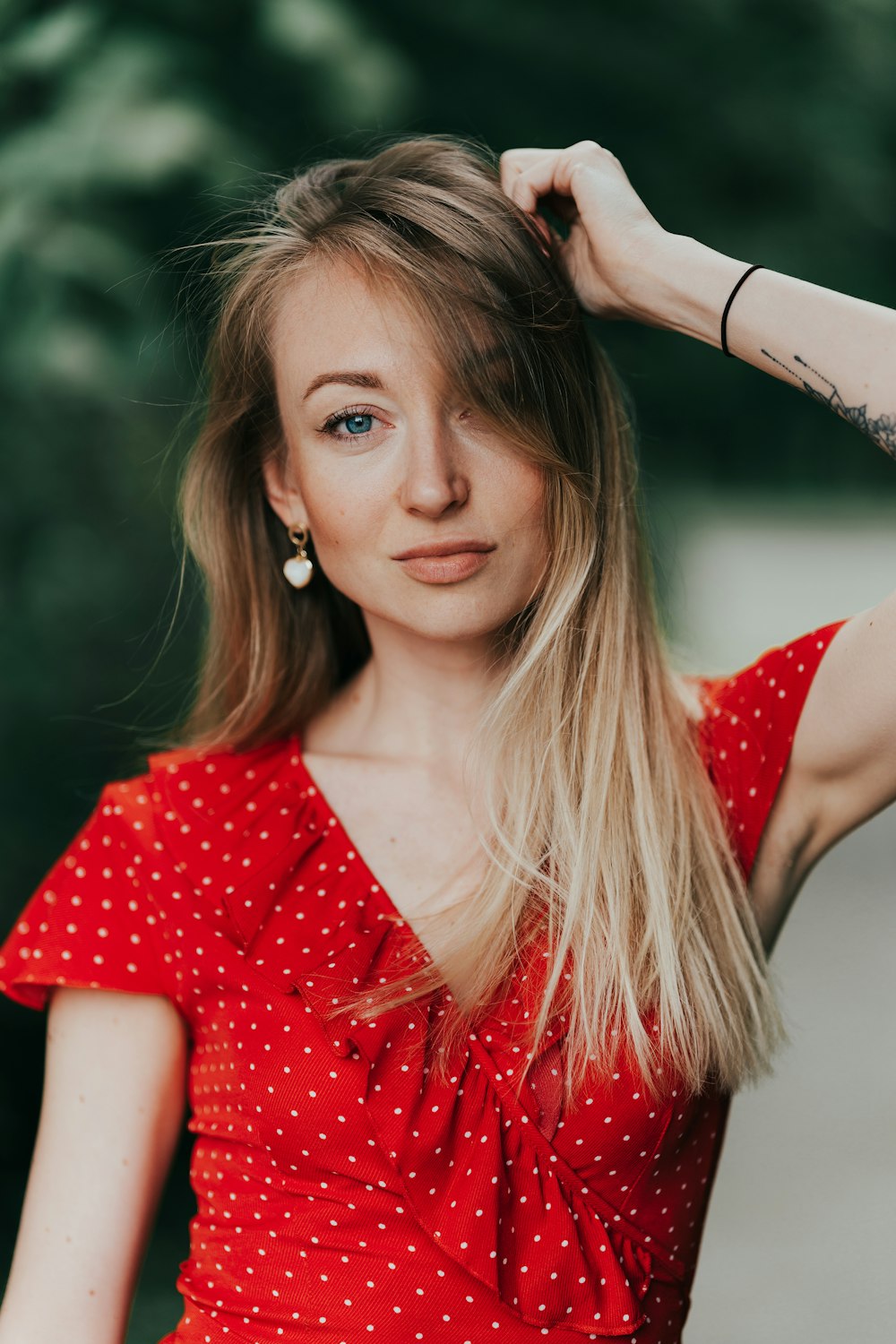 a woman in a red dress with a tattoo on her arm