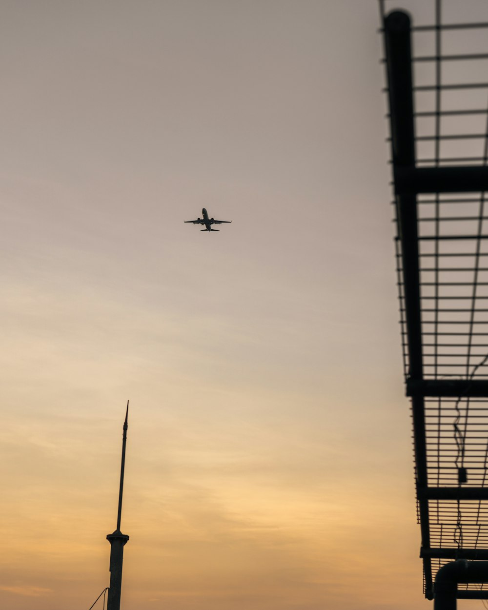 an airplane flying over a wind turbine at sunset