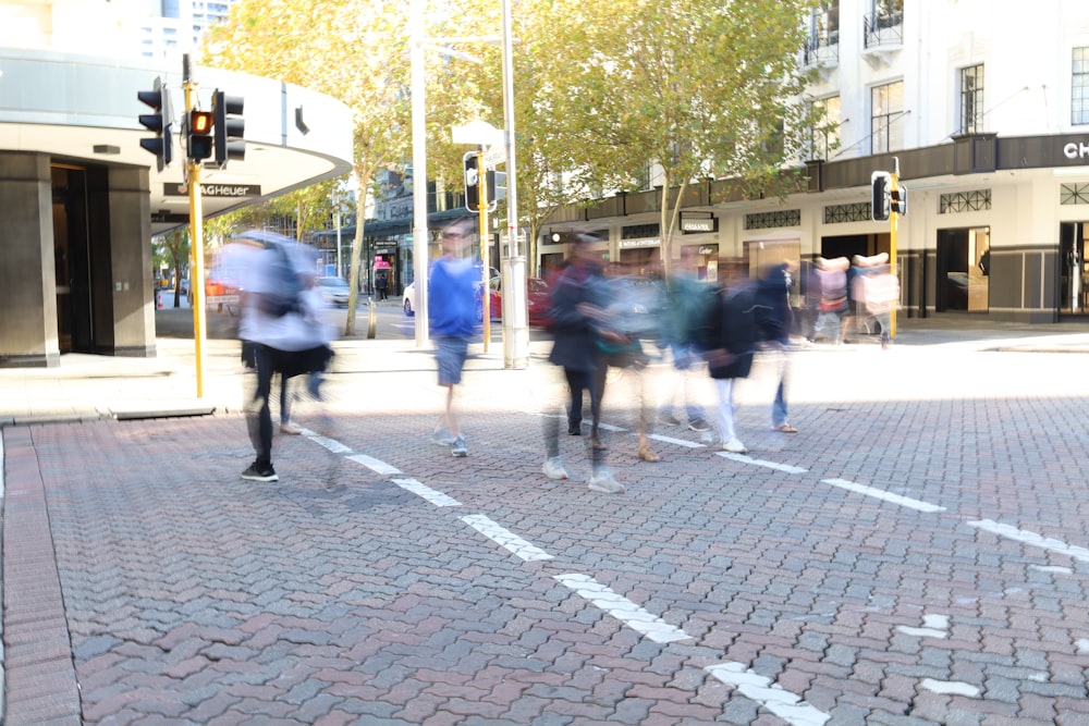 a group of people walking across a street