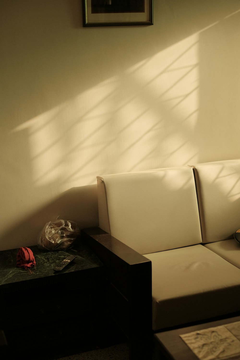 a white couch sitting under a window next to a table