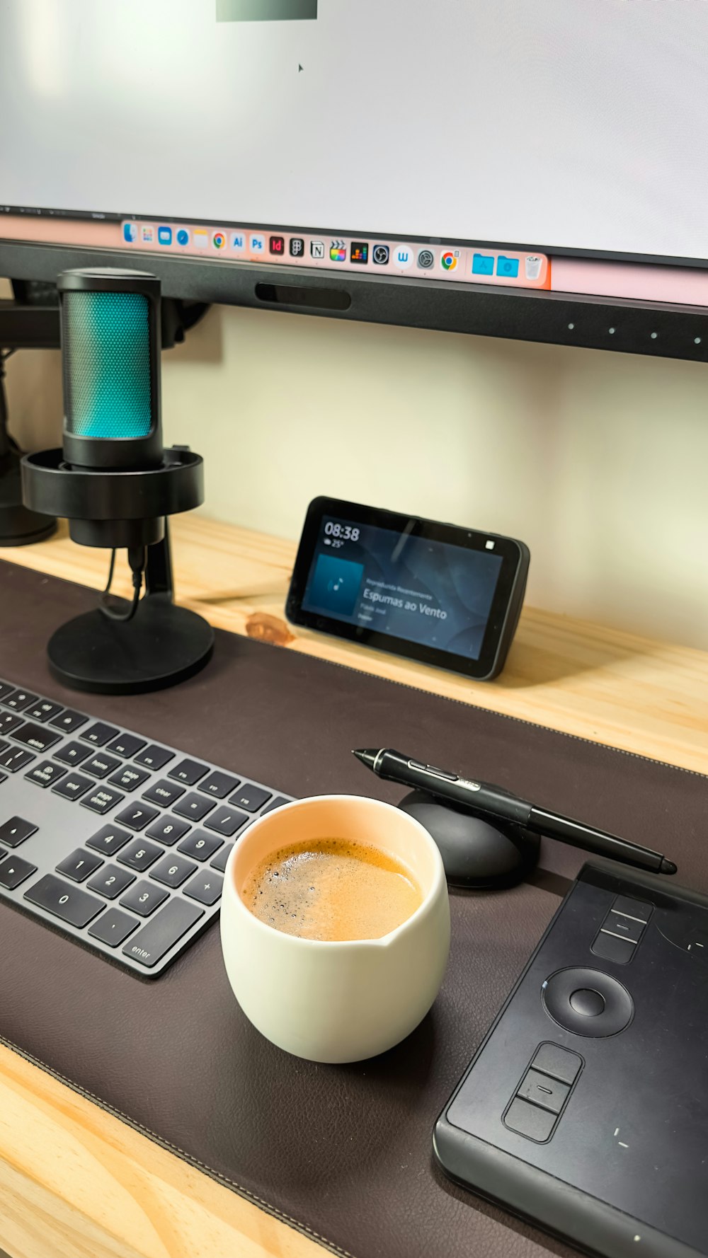 uma xícara de café sentada em uma mesa ao lado de um teclado