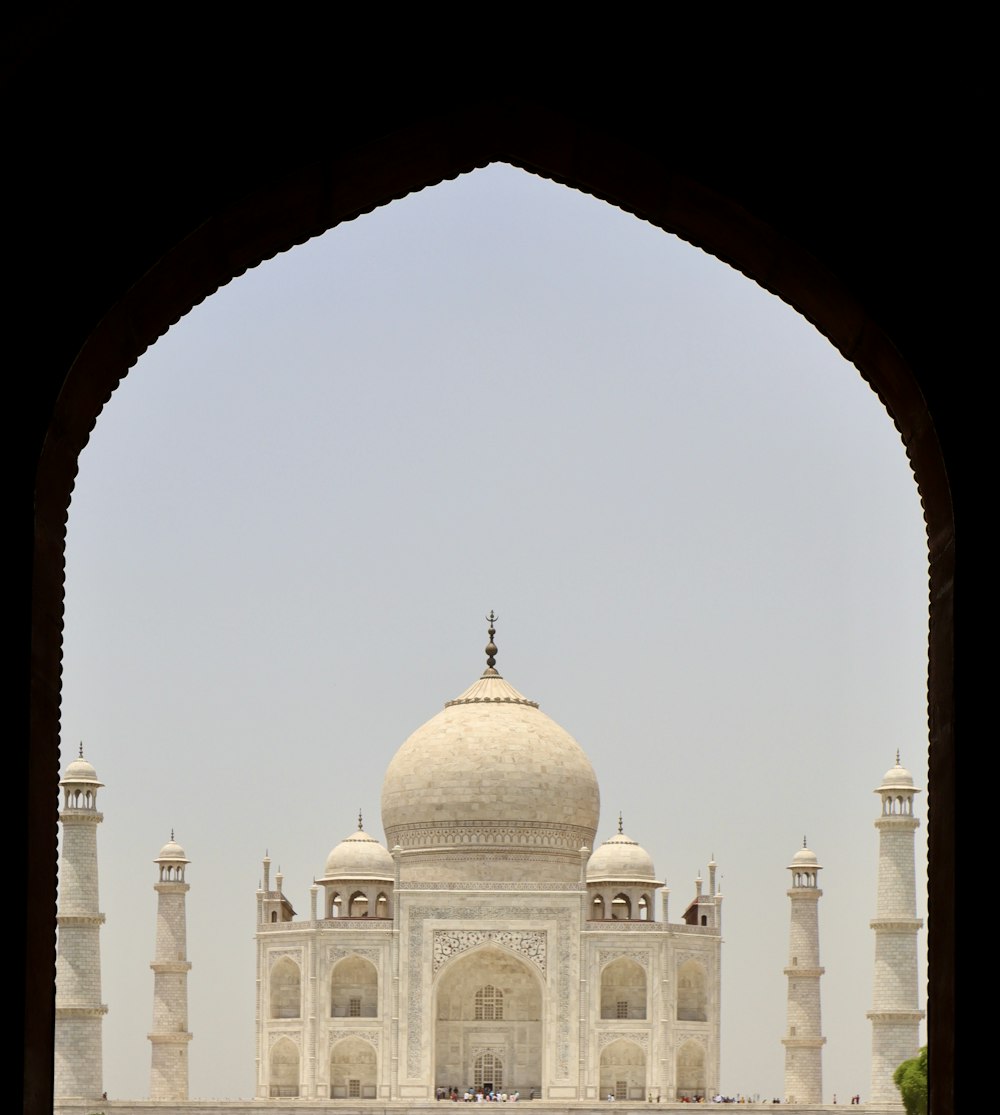 a view of a white building through an archway