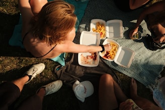 Happy customers enjoying Crispjoy Chips during a lively picnic in the park.