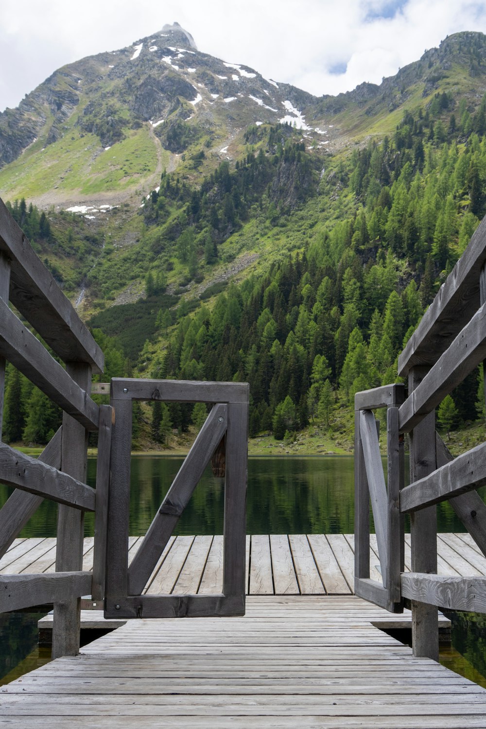 a wooden dock with a mountain in the background