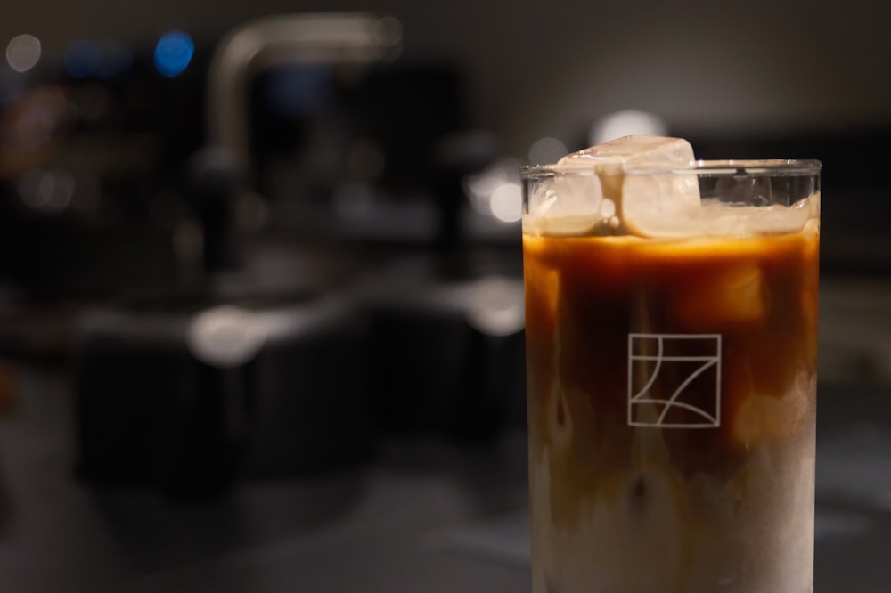 a glass of iced coffee sitting on top of a counter