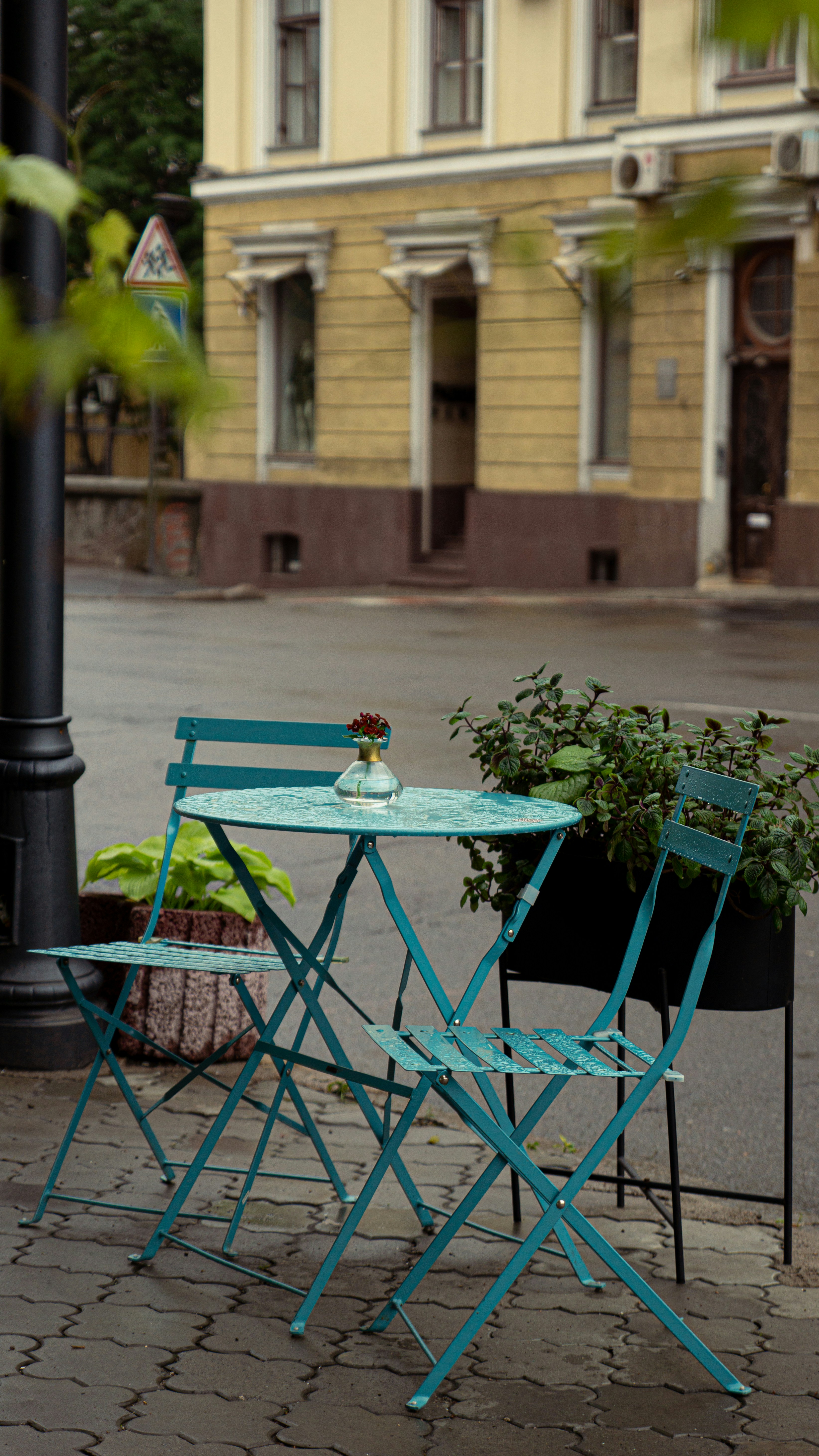 a couple of chairs and a table on a sidewalk