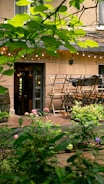 A cozy outdoor patio with wooden furniture and plants.