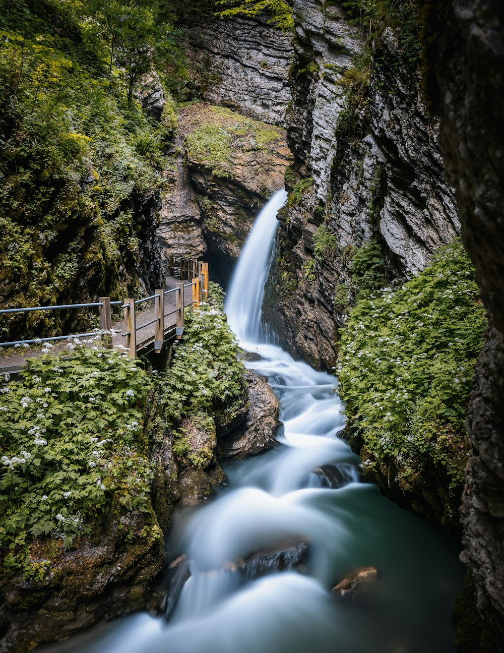 a small wooden bridge over a small waterfall