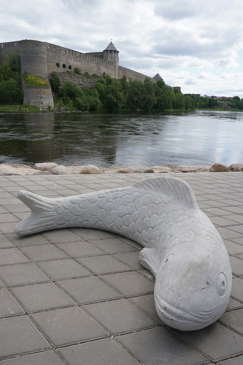 a statue of a fish laying on the ground